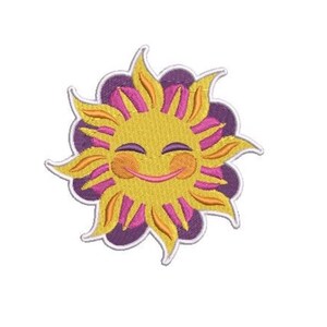 May include: An embroidered patch featuring a stylized yellow sun with a smiling face, closed eyes, and pink cheeks. The sun is layered over a purple flower-like shape with rounded petals, all outlined in white thread against a plain background.