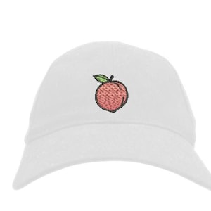 May include: White baseball cap with an embroidered peach design. The peach is pink with a green leaf.