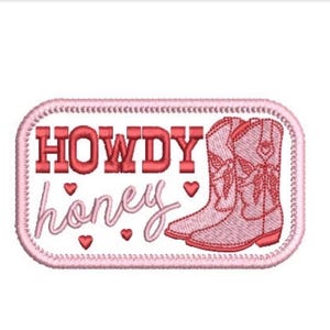 Könnte beinhalten: Ein rechteckiger gestickter Aufnäher mit abgerundeten Ecken, der den Text HOWDY in fetten roten Buchstaben und honey in kursiver rosa Schrift zeigt. Rechts befinden sich zwei rosa Cowboystiefel und drei kleine rote Herzen um den Text.