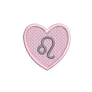 May include: A heart-shaped embroidered patch featuring a light pink textured background with a dark gray Leo zodiac symbol stitched in the center. The patch has a thick, raised light pink border that outlines the heart shape clearly.