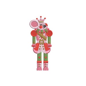 May include: A pink and green nutcracker with a crown and a red trumpet. The nutcracker has a whimsical expression and is holding the trumpet to its mouth.