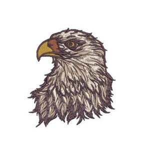 May include: An embroidered patch featuring the head of a bald eagle in profile. The design uses shades of white, gray, and brown thread to create detailed feather textures, with a prominent yellow beak and a dark eye looking toward the left.