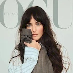 Könnte beinhalten: Vogue Deutsch Magazin-Cover mit Dakota Johnson. Sie trägt ein gestreiftes Hemd unter einer karierten Weste und Hose. Der Covertext lautet "The New Classics" und "Mode, Die Bleibt."