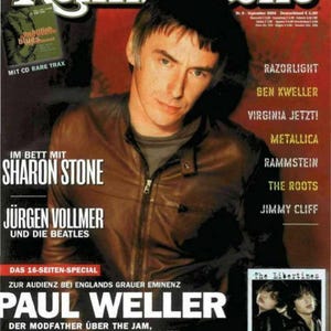 Puede incluir: Una portada de la revista Rolling Stone de septiembre de 2004 con Paul Weller vistiendo una chaqueta de cuero marrón. El texto incluye titulares sobre Sharon Stone, Jürgen Vollmer, The Beatles, The Libertines y varios artistas musicales.