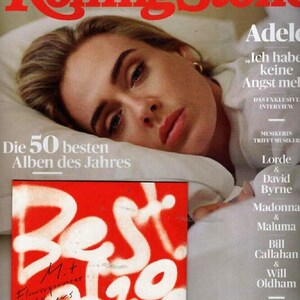 May include: A Rolling Stone magazine cover featuring a portrait of Adele lying on a white pillow. The text includes 2021 DER GROSSE JAHRES RÜCKBLICK, Die 50 besten Alben des Jahres, and a red square graphic with the white spray-painted text Best 2021.