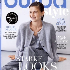 May include: The cover of Burda Style magazine, issue 11/2025, features a woman smiling. She wears a gray cardigan, a satin top, and striped pants. The magazine cover includes text such as "STARKE LOOKS" and "BELLE DE JOUR."
