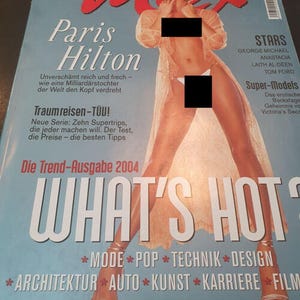 Puede incluir: Un número de 2004 de la revista Max con Paris Hilton en la portada. La portada tiene un fondo azul claro con el título rojo Max, texto en blanco que incluye Paris Hilton, What's Hot y varios titulares en alemán. Una persona viste una bata transparente.