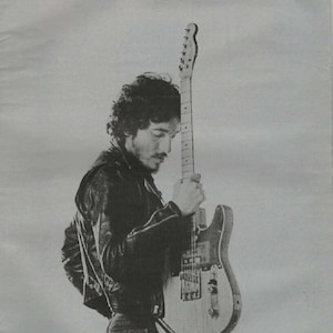 May include: Black and white magazine cover featuring a man holding a guitar. The magazine title is "ZEIT MAGAZIN" with the text "MANCHMAL WÄRE ICH GERN WIE BRUCE SPRINGSTEEN". The cover is dated November 2016.