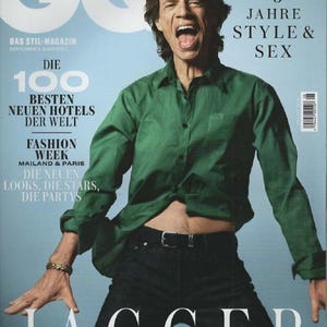 Könnte beinhalten: Ein GQ Deutschland Magazin-Cover mit Mick Jagger, der ein langärmeliges grünes Hemd und eine dunkle Jeans trägt. Der Text lautet GQ, 75 JAHRE STYLE & SEX, DIE 100 BESTEN NEUEN HOTELS DER WELT, FASHION WEEK MAILAND & PARIS, DIE NEUEN LOOKS, DIE STARS, DIE PARTYS und JAGGER.