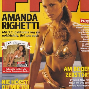 May include: A January 2006 issue of FHM magazine featuring a cover photograph of Amanda Righetti wearing a metallic gold bikini. The cover includes bold red and yellow text, a smaller inset image of a person in a white bikini, and a barcode.