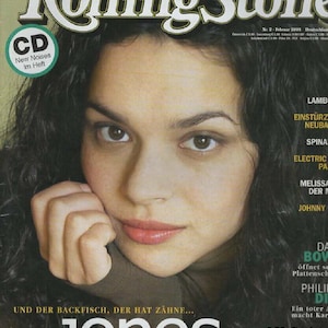 May include: A February 2004 issue of Rolling Stone magazine featuring a portrait of Norah Jones on the cover. The cover includes the text MUSIK AUF DVD: DAS 16-SEITEN-SPECIAL, CD New Noises im Heft, and the headline UND DER BACKFISCH, DER HAT ZÄHNE... norah jones schwimmt sich frei.