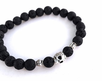 Black Lava Stone bracelet with Sugar Skull bead. Men's stretch bracelet is a memento mori and a men's diffuser bracelet