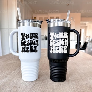 May include: Two stainless steel travel mugs with lids and handles. The mug on the left is white with black text that says "Your Design Here". The mug on the right is black with white text that says "Your Design Here".