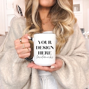 May include: White ceramic mug with a black rim and handle. The mug has black text that reads "YOUR DESIGN HERE Lauridamocks".