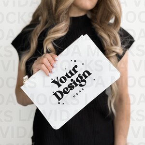 May include: A white clutch purse with a zipper closure. The purse has the text "Your Design Here" printed on the front in black.