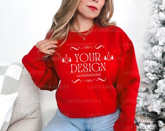 May include: Red sweatshirt with white text that says "Your Design" with a Christmas tree design on either side of the text. The sweatshirt has a crew neck and long sleeves.