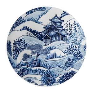 Pode incluir: Um prato de cerâmica azul e branco com um design de paisagem japonesa tradicional. O prato apresenta um edifício de pagoda de vários níveis, árvores e montes.