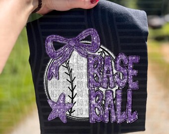 May include: Black t-shirt with a baseball design. The design features a baseball with the word "BASEBALL" in purple glitter, a purple bow, and a purple star. The shirt has a striped pattern.