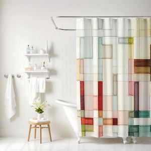 The shower curtain shown has a geometric pattern made up of squares and rectangles in varying sizes. These shapes are filled in with watercolor and are arranged in a random pattern. Colors include shades of pink, peach, yellow, red, green, and brown.