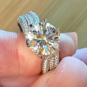 Moissanite ring. A 5ct certified Moissanite ring with a ribbed cigar-style band and pavé-set white zircons! The design is just exquisite!
