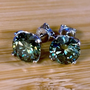 Moissanite studs. A 6cttw pair of cyan (bluish-green) Moissanite studs. Double certified, inscribed and rich in color, they are delicious!