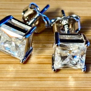 Moissanite studs. A perfect certified pair of 2cttw princess-cut Moissanites in solid sterling silver bathed in luxurious 18k white gold!