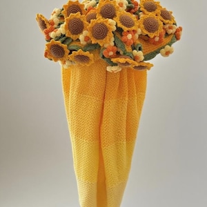 Puede incluir: Una toalla de punto amarilla para colgar con un adorno superior de girasoles de ganchillo y peque&ntilde;as flores naranjas y blancas. La toalla tiene un dise&ntilde;o de color amarillo degradado y el texto Yellow Sunflower aparece en la esquina inferior.