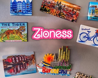 May include: A collection of rectangular and shaped souvenir magnets featuring various international city landmarks, including Saint Petersburg, Amsterdam, Prague, Barcelona, Venice, and Croatia, with the word Zioness in pink text in the center.
