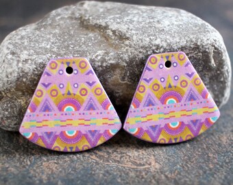 May include: Two fan-shaped earrings with a lavender background and a colorful geometric pattern. The design includes triangles, circles, and lines in gold, purple, teal, and yellow. Each earring has a small hole at the top for hanging.