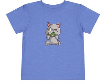 May include: A light blue toddler t-shirt with a cartoon image of a gray rhinoceros eating a green leaf.