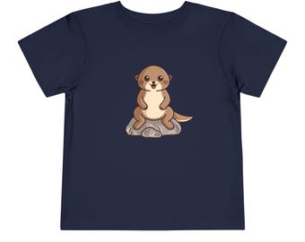 May include: A navy blue toddler t-shirt with a cartoon image of a brown otter sitting on a gray rock.