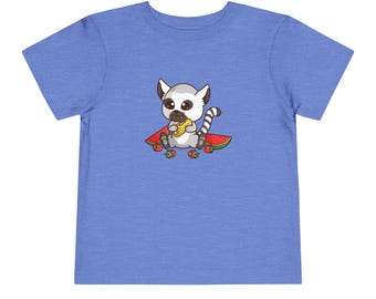 May include: A blue toddler t-shirt with a cartoon image of a lemur eating a piece of corn on the cob. The lemur is sitting on a slice of watermelon with strawberries around it.