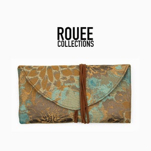 May include: A brown and blue floral patterned fabric clutch with a brown leather flap and a brown cord closure. The clutch has the text "ROUEE COLLECTIONS" printed on it.
