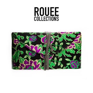 May include: A black fabric clutch with a green and purple floral pattern and a gray drawstring closure. The clutch has the text "ROUEE COLLECTIONS" printed on it.