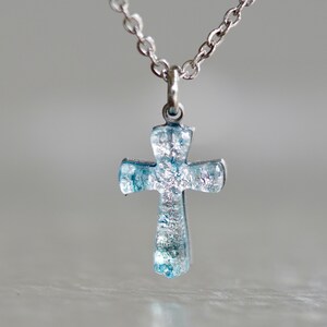 small cross necklace made of silver color dichroic glass