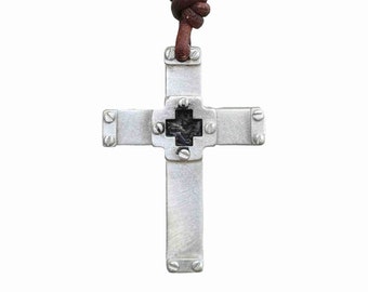 May include: A silver cross pendant with a black cross in the center, attached to a brown leather cord.