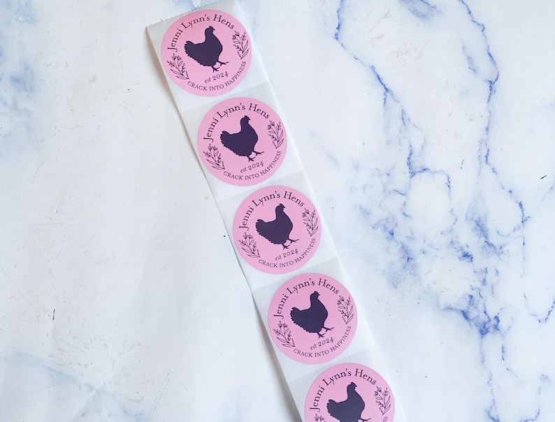 May include: Pink circular stickers with a black hen silhouette, text that reads "Jenni Lynn's Hens" and "est 2024 Crack into Happiness". The stickers are on a white backing.