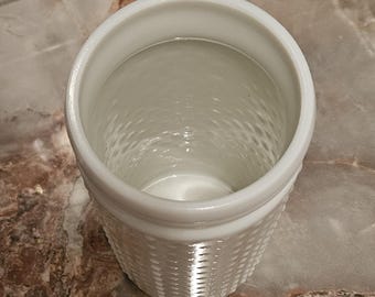 Een vintage melkglazen spijkerpot of vaas