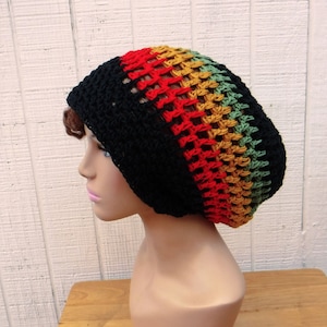 May include: A black crochet beanie with red, yellow, and green stripes. The beanie is made with a loose stitch and has a slouchy fit.