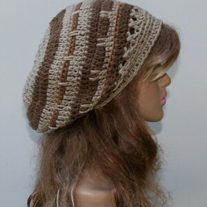 May include: A brown and beige crocheted beanie hat with a slouchy fit.