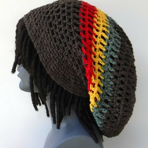 May include: A brown crocheted beanie with a red, yellow, and green stripe. The beanie is worn on a mannequin with dreadlocks.