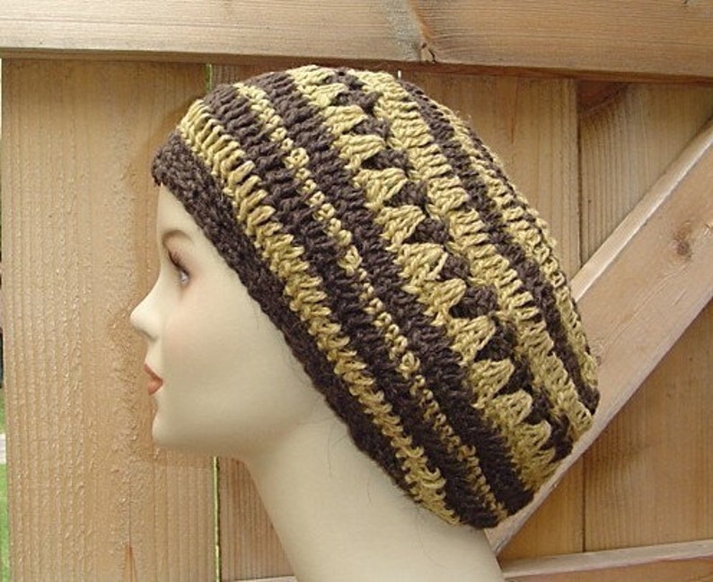 Peut inclure: Un bonnet en crochet beige et marron avec un motif textur&eacute;.