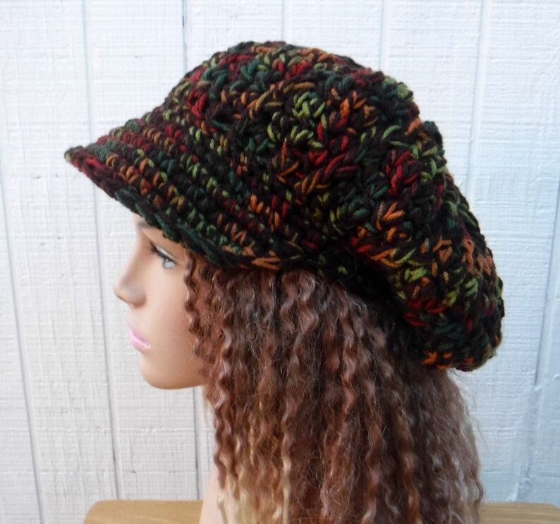 May include: A brown, green, and orange crocheted beanie with a brim. The beanie is slouchy and has a casual style.