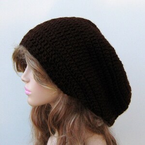 May include: A brown crocheted beanie hat with a slouchy fit.