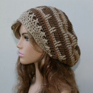 May include: A brown and beige crocheted beanie with a striped pattern. The beanie is slouchy and has a loose fit.
