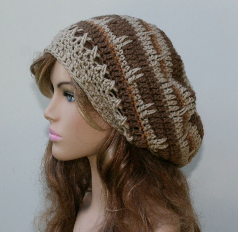 May include: A brown and beige crocheted beanie with a striped pattern. The beanie is slouchy and has a loose fit.