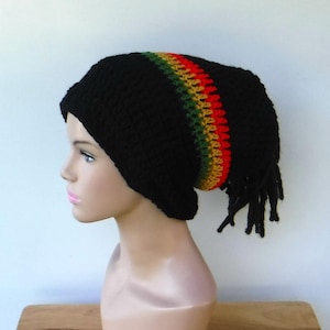May include: Black crochet beanie with a red, yellow, and green stripe. The beanie has a long, black, crocheted tail.
