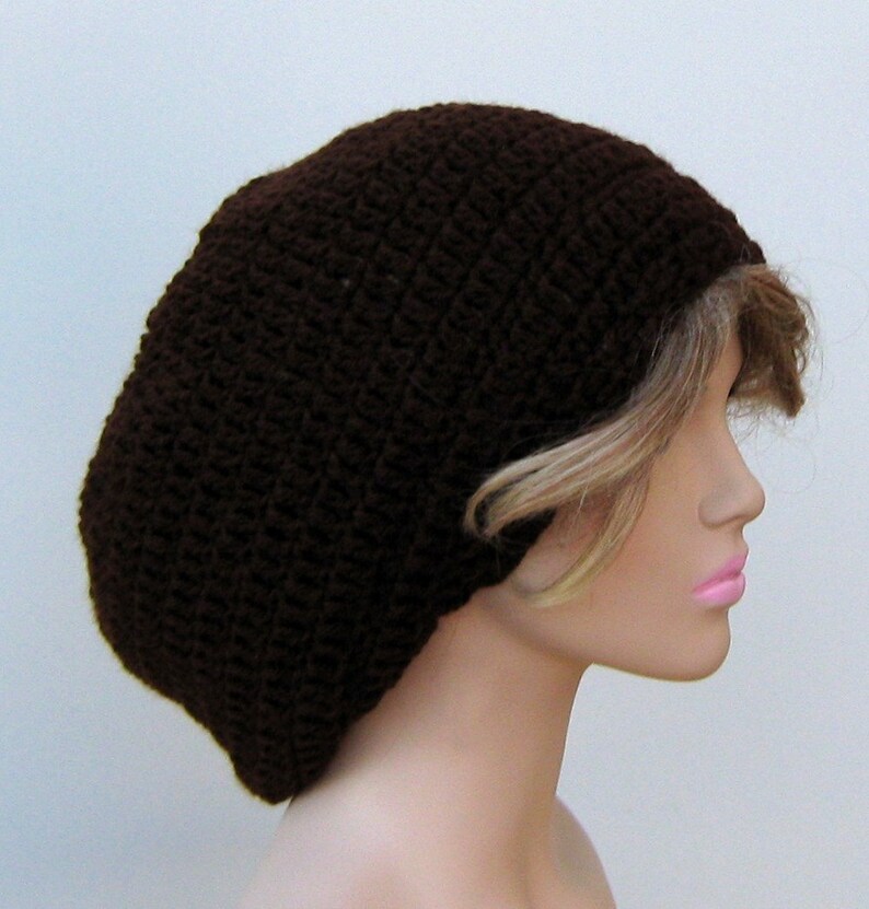 May include: A brown crocheted beanie hat with a slouchy fit. The hat is made with a simple stitch pattern and has a relaxed, casual look.