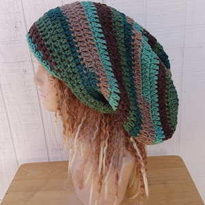 May include: A crocheted beanie hat with a slouchy fit. The hat is striped in shades of brown, green, and teal.
