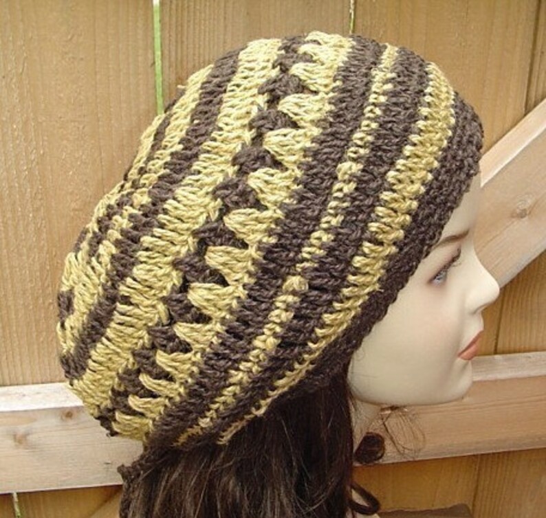 Peut inclure: Un bonnet crochet&eacute; brun et beige avec un motif ray&eacute;.